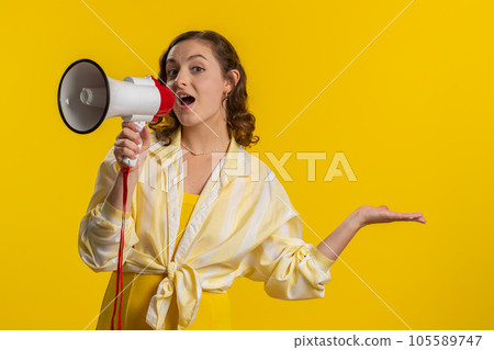 Woman talking with megaphone, proclaiming news, loudly announcing advertisement pointing empty place 105589747