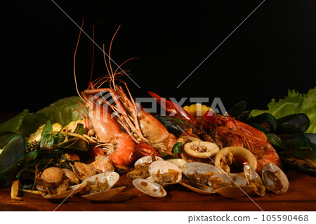 Mixed sea food on the wooden plate with black background. 105590468