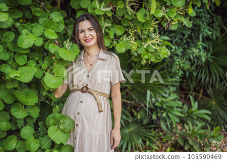 A serene and radiant pregnant woman after 40, surrounded by nature's beauty in the park, cherishing the journey of motherhood with a glowing smile A serene and radiant pregnant woman after 40, surrounded by nature's beauty in the park, cherishing the journey of motherhood with a glowing smile 105590469