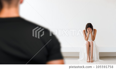 Woman crying while being watched by a man 105591758