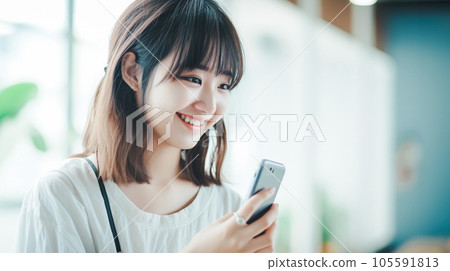 A smiling woman who operates a smartphone 105591813