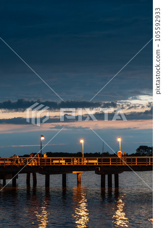 night molo pier with lantern yellow light at Polish village Jastarnia, sunset 105592933