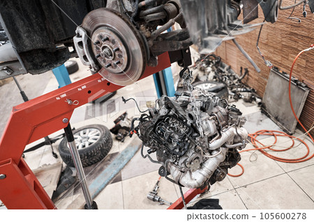 Rusty disc brakes, front on car. Change the old to new brake disc on car in a garage. Auto mechanic repairing 105600278