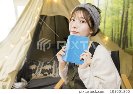 家庭露營圖片一位年輕女子在帳篷前看書 家庭露營圖片一位年輕女子在帳篷前看書 105601800