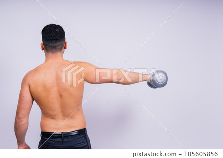 Athletic man doing exercises with dumbbell at biceps on white background. Strength and motivation Athletic man doing exercises with dumbbell at biceps on white background. Strength and motivation 105605856