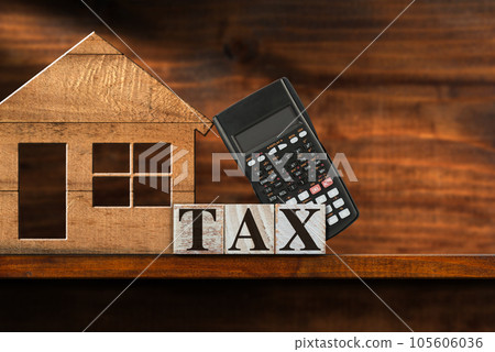 Wooden Text Tax and Small Model House with a Calculator on a Shelf 105606036