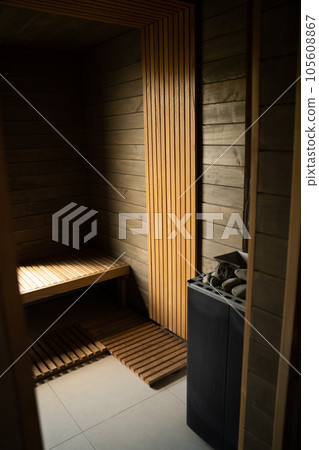 Empty traditional finnish sauna room with window and wooden wall, bench in modern luxurious hotel. Empty traditional finnish sauna room with window and wooden wall, bench in modern luxurious hotel. 105608867