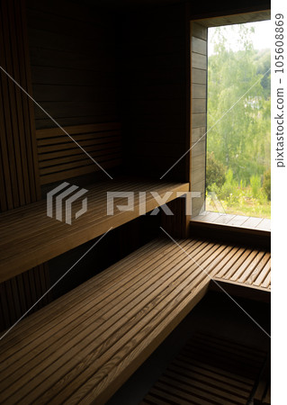 Modern wooden Finnish sauna interior with wooden benches. Wooden interior baths, wooden benches and loungers accessories for sauna, spa complex. 105608869