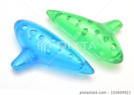Colorful children's ocarina in blue and green translucent colors made of plastic, white background 105609921