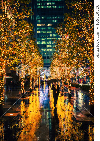 A men with umbrella in illuminated alley at rainy night, Tokyo 105610526