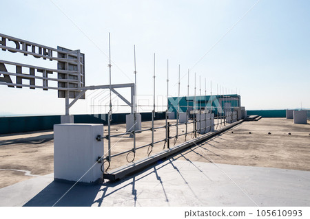 Rooftop small radio communication tower antenna and television. Sky with bright sunlight is background. Is device that converts electricity into electromagnetic waves. modern technology. Rooftop small radio communication tower antenna and television. Sky with bright sunlight is background. Is device that converts electricity into electromagnetic waves. modern technology. 105610993