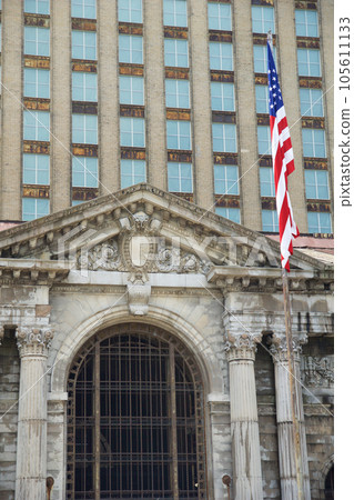DETROIT, MICHIGAN, UNITED STATES - MAY 5th 2018: A view of the old Michigan Central Station building in Detroit which served as a major railway depot from 1914 - 1988, detailed view with the american DETROIT, MICHIGAN, UNITED STATES - MAY 5th 2018: A view of the old Michigan Central Station building in Detroit which served as a major railway depot from 1914 - 1988, detailed view with the american 105611133