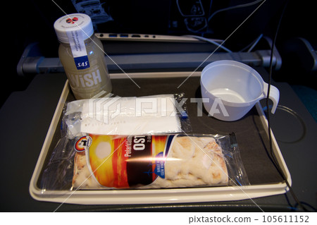 STOCKHOLM, SWEDEN - 24 NOV 2018: Inflight snack on an economy class flight. Plane meal consisting of smoothie and wrap STOCKHOLM, SWEDEN - 24 NOV 2018: Inflight snack on an economy class flight. Plane meal consisting of smoothie and wrap 105611152