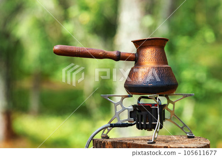 Brewing coffee on camping stove Brewing coffee on camping stove 105611677