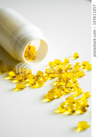 Fish oil capsules with omega 3 on white table. Healthy diet concept. Filled soft gel supplements for diet. Health care concept. Fish oil capsules with omega 3 on white table. Healthy diet concept. Filled soft gel supplements for diet. Health care concept. 105611857
