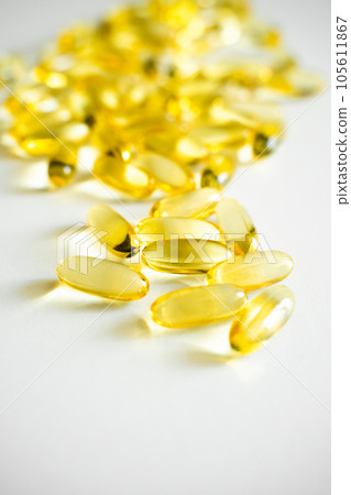 Fish oil supplement capsules on a white surface as a background. Oil filled capsules of food supplements. Fish oil, omega 3. Fish oil supplement capsules on a white surface as a background. Oil filled capsules of food supplements. Fish oil, omega 3. 105611867