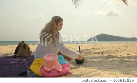 The cheerful woman in holding and eating slices of watermelon on tropical sand beach sea. Portrait attractive girl spend summer weekend. The cheerful woman in holding and eating slices of watermelon on tropical sand beach sea. Portrait attractive girl spend summer weekend. 105612839
