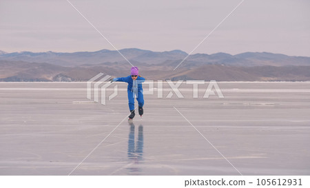 The girl train on ice speed skating. The child skates in the winter in blue sportswear suit, sport glasses. Children speed skating sport. 105612931