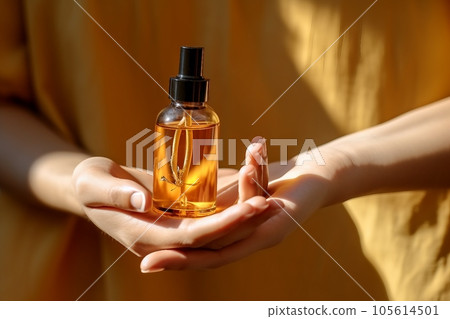 Mockup of glass bottle with dropper lid in female hands. Amber-colored container with cosmetic product, serum on brown background in rays of sunlight. Concept of beauty. Mockup of glass bottle with dropper lid in female hands. Amber-colored container with cosmetic product, serum on brown background in rays of sunlight. Concept of beauty. 105614501