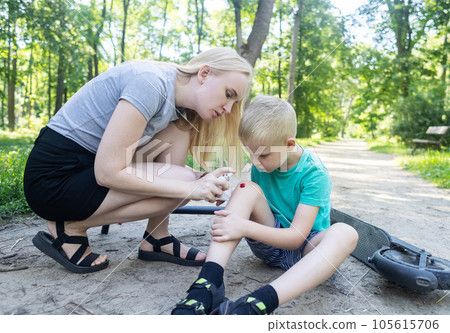 Kid fall when riding an electric scooter. Riding an e-scooter without protective gear. Increased risk of injury when using battery powered vehicles. Mom gives first aid for a knee injury 105615706