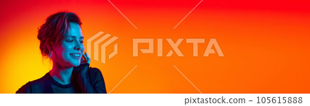 Banner. Close up of young woman in sunglasses and black transparent top touching hair over gradient yellow-red neon background. 105615888