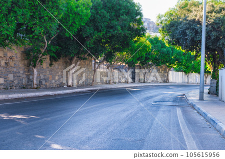 Rural empty asphalt road with sharp turn, asphalt road in the city with green trees. 105615956