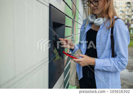 Woman client using automated self service post terminal machine or locker. Mail shipping concept 105616302