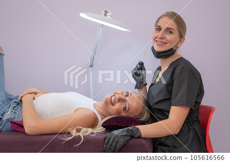 Caucasian woman on eyelash extension procedure. Caucasian woman on eyelash extension procedure. 105616566