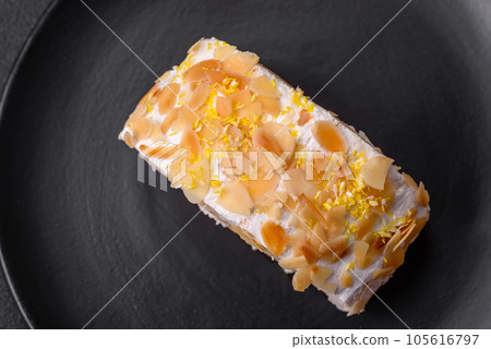 Delicious, fresh, sweet meringue roll with cream, almond chips, nuts and berries 105616797