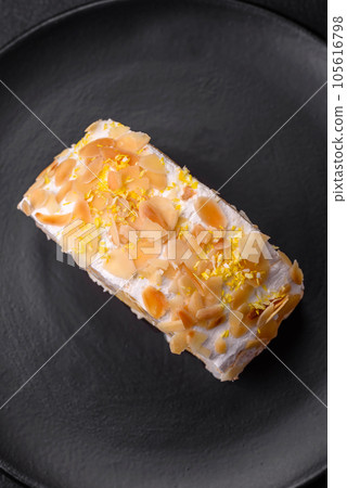 Delicious, fresh, sweet meringue roll with cream, almond chips, nuts and berries 105616798