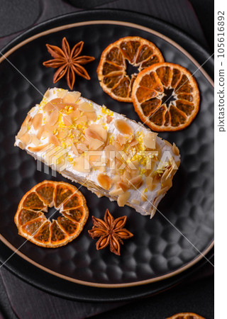 Delicious, fresh, sweet meringue roll with cream, almond chips, nuts and berries 105616892