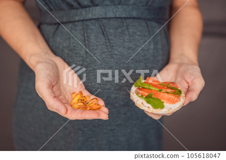 A thoughtful pregnant woman over 40 considering whether to eat fish or opt for omega 3 capsules for a nourishing and healthy pregnancy A thoughtful pregnant woman over 40 considering whether to eat fish or opt for omega 3 capsules for a nourishing and healthy pregnancy 105618047