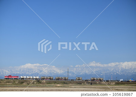 A freight train on the Takayama Main Line running against the backdrop of the Tateyama mountain range 105619867