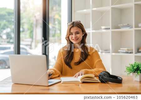 Young female student study in home. Asian woman in online learning , watching educational webinar on laptop Young female student study in home. Asian woman in online learning , watching educational webinar on laptop 105620463