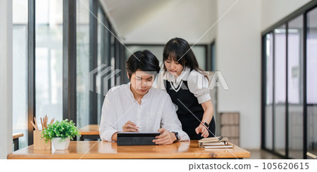 Two Asian businesspeople working discussion business matters at office Two Asian businesspeople working discussion business matters at office 105620615