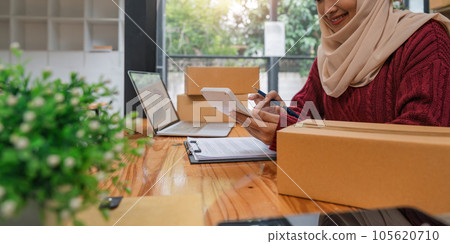 Small startup muslim woman checking parcels at work, freelancers, salespeople, checking production orders. Pack products to send to customers. Sell ecommerce shipping Ideas 105620710