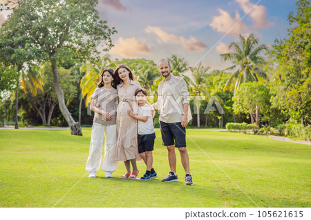 A loving family enjoying a leisurely walk in the park - a radiant pregnant woman after 40, embraced by her husband, and accompanied by their adult teenage children, savoring precious moments together A loving family enjoying a leisurely walk in the park - a radiant pregnant woman after 40, embraced by her husband, and accompanied by their adult teenage children, savoring precious moments together 105621615
