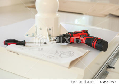 Cordless screwdriver on wood table assembly furniture concept Cordless screwdriver on wood table assembly furniture concept 105621898