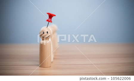 Business and human resources concept for leadership and team leader. A red pin pinned on one wooden doll stands apart and stands out from the crowd. 105622006