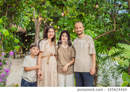 A loving family enjoying a leisurely walk in the park - a radiant pregnant woman after 40, embraced by her husband, and accompanied by their adult teenage children, savoring precious moments together 105624484