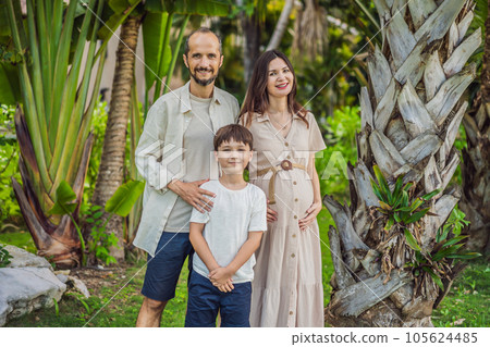 A loving family enjoying a leisurely walk in the park - a radiant pregnant woman after 40, embraced by her husband, and accompanied by their adult teenage son, savoring precious moments together 105624485