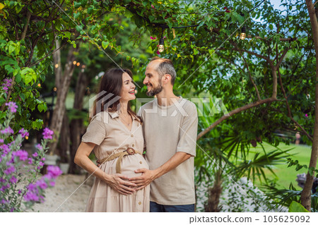 A blissful scene in the park as a radiant pregnant woman after 40 and her loving husband after 40, cherish the joy of parenthood together, surrounded by nature's serenity 105625092