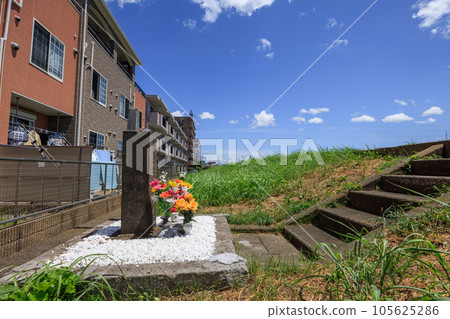 Housing complex on the side of the river bank and the grave of an unrelated Buddha Housing complex on the side of the river bank and the grave of an unrelated Buddha 105625286
