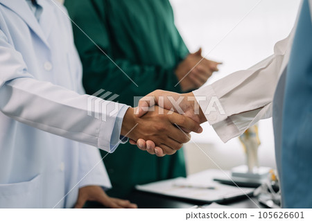 Doctors holding hands together at hospital. 105626601