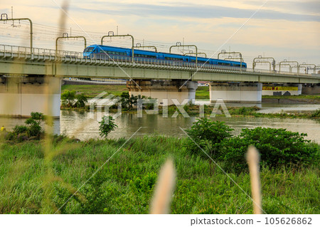 Odakyu Romancecar crossing the iron bridge illuminated by the setting sun 105626862