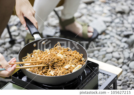Men and women making yakisoba outdoors Outdoor image 105627215