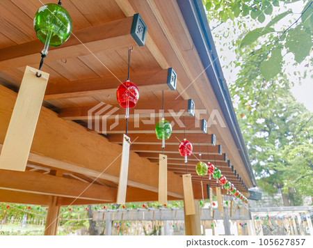 Colorful wind chimes hanging under the eaves of a shrine 105627857