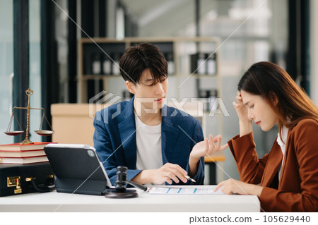 Business people compassionately holding hands and discussing contract papers with laptop and tabletat in office room. 105629440