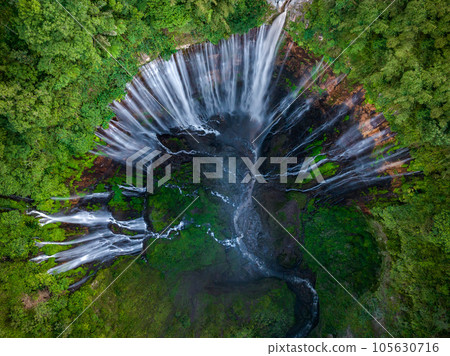 Aerial top view from above of Tumpak Sewu ,also known as Coban Sewu, 120m high waterfall in Malang regency, East Java, Indonesia Aerial top view from above of Tumpak Sewu ,also known as Coban Sewu, 120m high waterfall in Malang regency, East Java, Indonesia 105630716