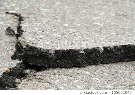 Selective focus on broken pavement road.Broken pavement road background and texture. 105631043